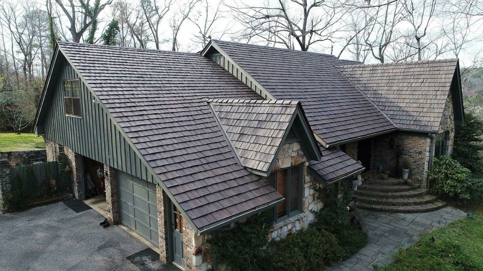 Stone home with cedar shake style designer roof