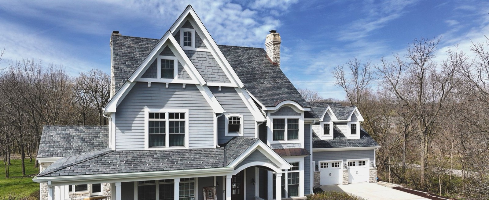 Home with a new designer shingle roof installed before storm season